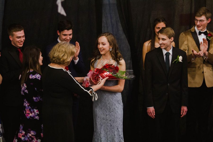 Prom Queen, Lauren Franzen, accepts roses from a member of the Prom Committee.