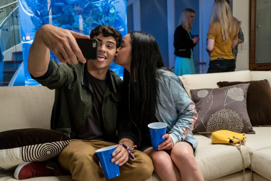 Characters Peter and Lara Jean take a selfie at a party. To All The Boys Ive Loved Before is the Netflix movie based on the Jenny Han novel.