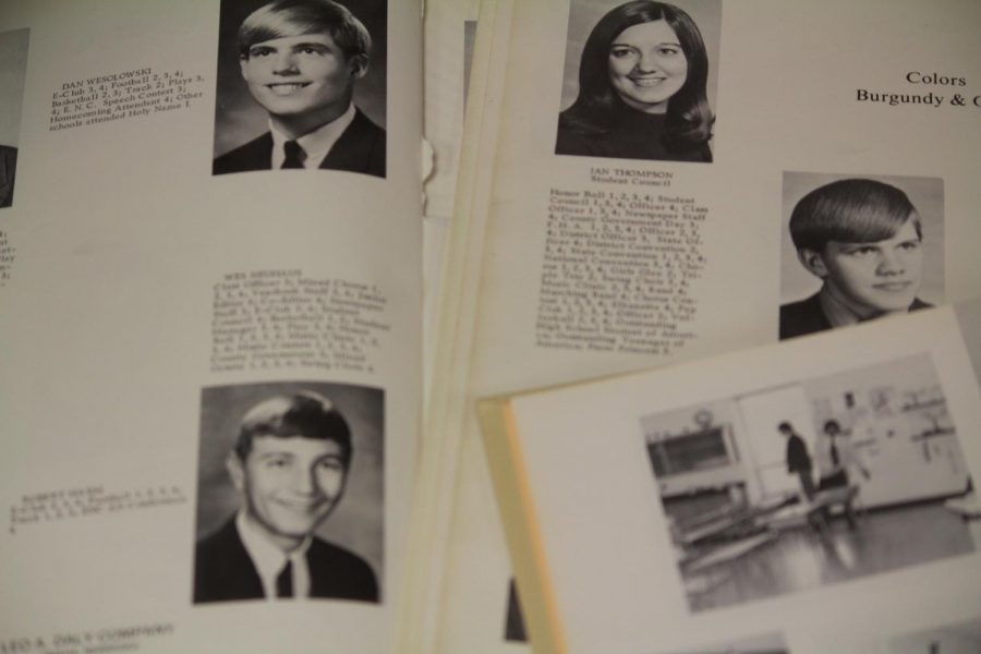 An older Elkhorn yearbook flipped to a page full of seniors. Many past yearbooks have damage to them.