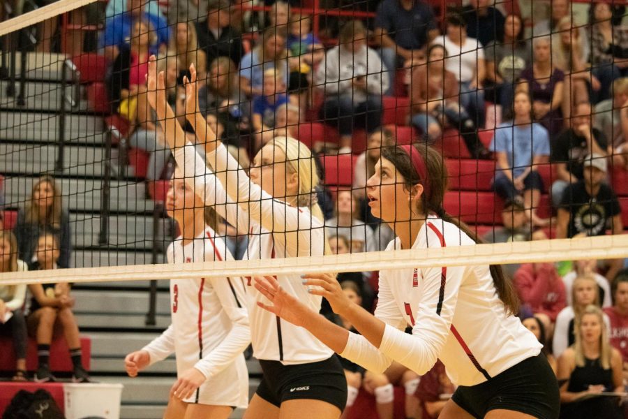 Senior Emma Crouch (4) and Junior Abby Wolfe (7) preparing to block the next hit volleyball.