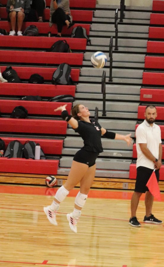 Kaelyn Anderson serving the volleyball. 