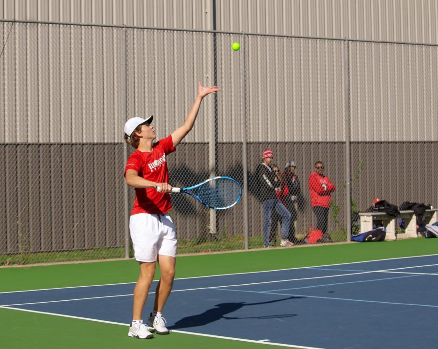 Scott Riddell throws up the ball to serve to his opponent while playing Alliance High School.