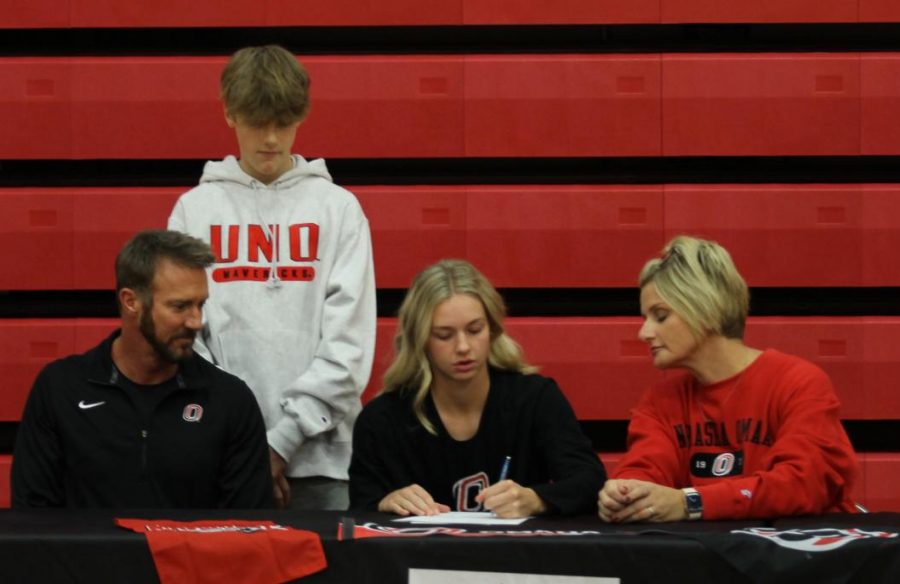 Senior Ella Dalton signs her letter of intent as her family looks on. Dalton will play softball at the University of Nebraska-Omaha.
