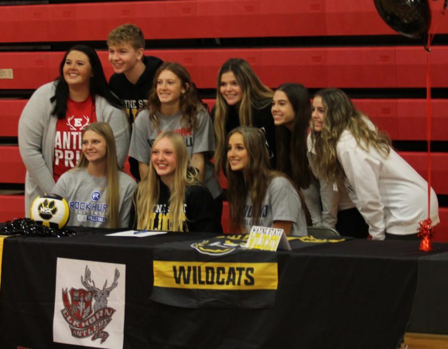 Sydney Raszler, Taylor Bunjer and Hannah Fast celebrate signing day with their teammates and coach. All three seniors will play volleyball collegiately.