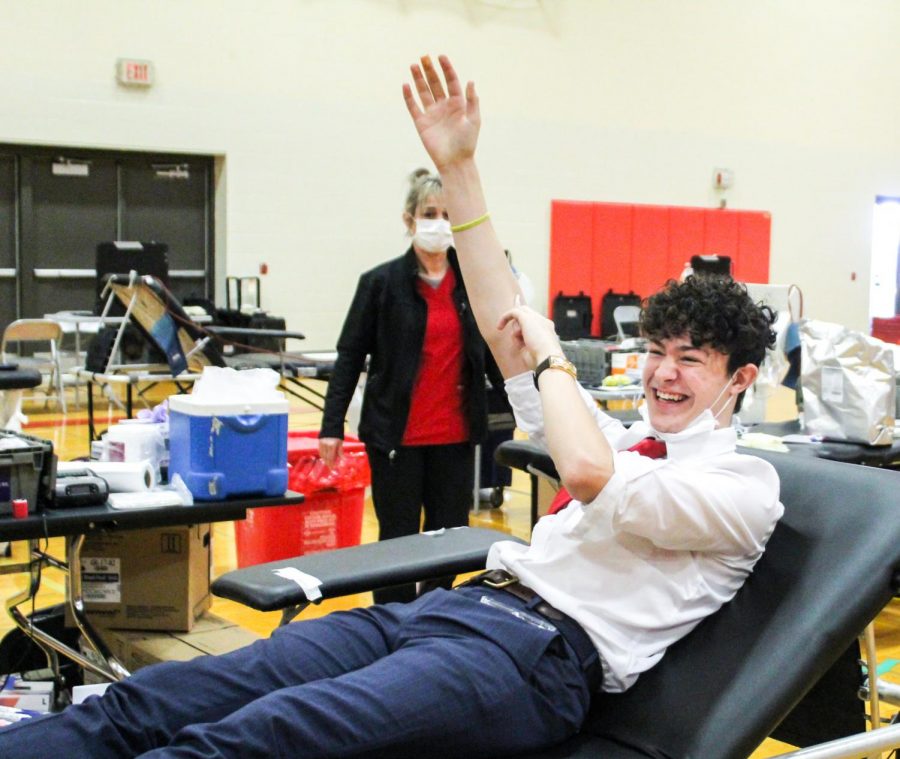 Isaac Workman smiles while donating  blood to those who need it at the blood drive. 