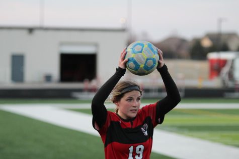 Emily Frain throws the soccer ball back into play.
