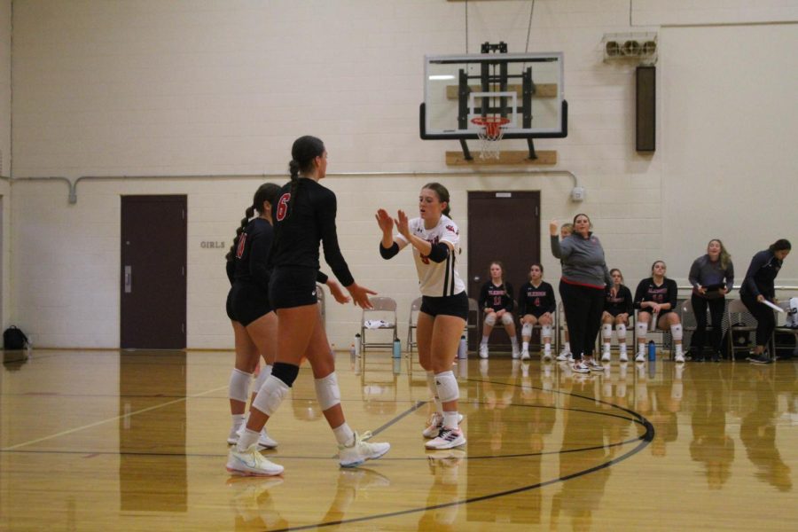 Seniors, Kaelyn Anderson and Haley Wolfe high five in the third set.