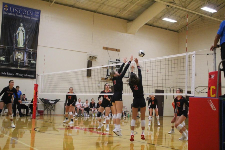 Ella Schutte and Addie Hunt jump to block a spike from Beatrice.