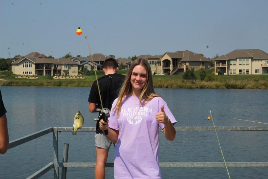 Emmy McElhose throwing a big thumbs up to the fish she caught.