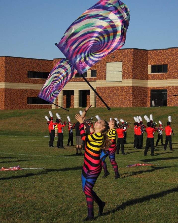 Junior Darla Crews throws her flag during the bands warm up. 