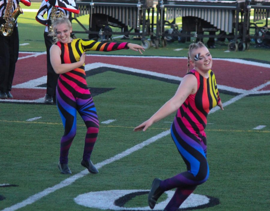 Darla Crews and Phoenix Erwin run to get their next flag during the performance. 