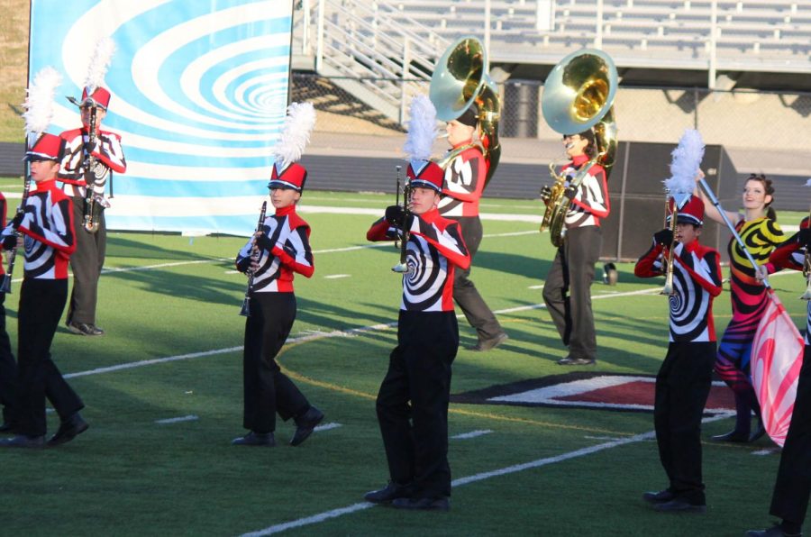 The marching band walks with their instruments during their performance.