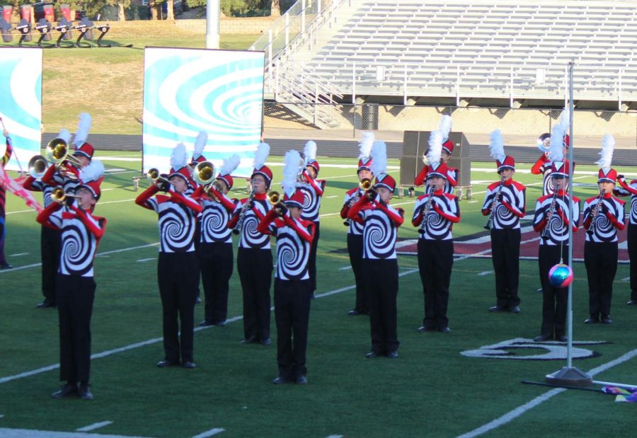 The+Pride+of+the+Antlers+marching+band+plays+their+instruments+together+on+the+field.+