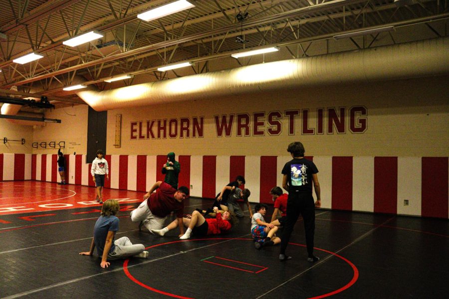 Boy wrestlers come together before Open Mat begins. Wrestlers prepare for the new season. 