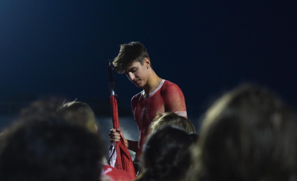 Senior Nate Roberts waits to start the student section huddle after the game. Red beat White 62-7 on Friday, August 18th.