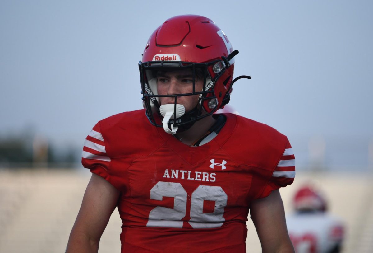 Junior Elliot Beister walks to his place on the field during the scrimmage. Red beat White 62-7 on Friday, August 18th.