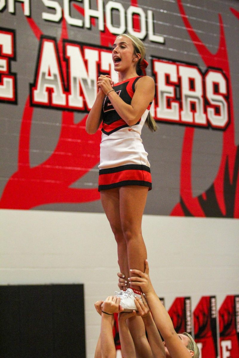 Senior Adri Wallace gets the crowd going with a difficult stunt. The Elkhorn Cheer team attends sporting events to keep the energy high.