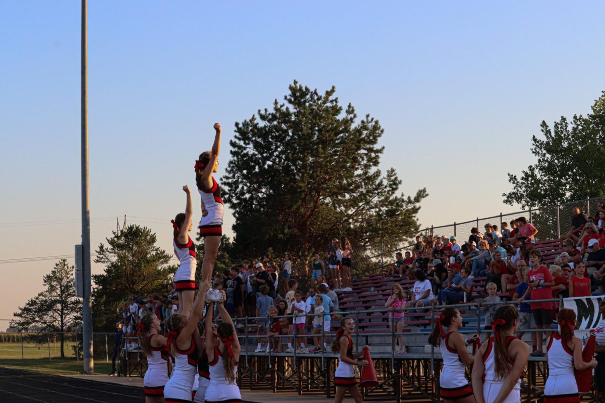 Elkhorn cheerleaders stunting while cheering on the football team. 