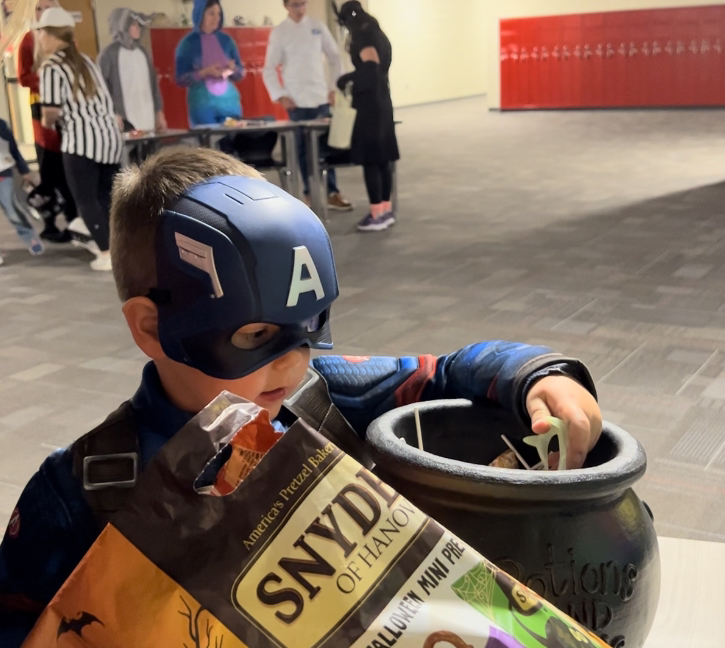 Captain+America+grabs+some+candy+during+Trunk+or+Treat.+Trunk+or+Treat+took+place+indoors.+