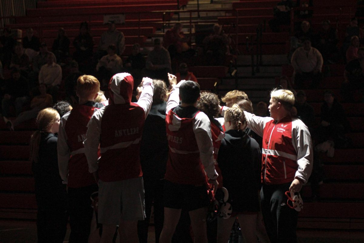 The+Antler+wrestling+team+does+a+team+cheer+in+the+middle+of+mat.+The+team+defeated+Conestoga.+