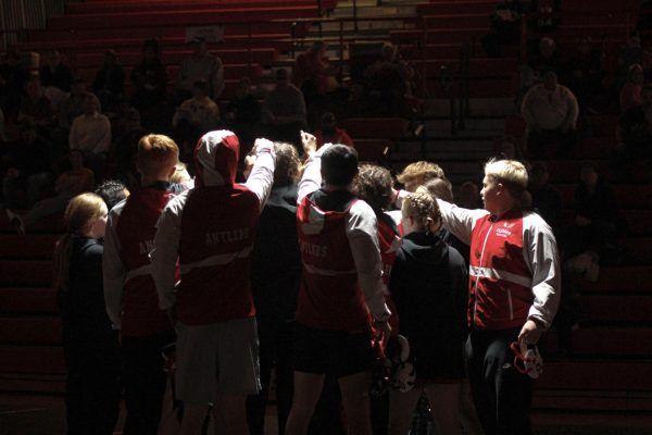 The Antler wrestling team does a team cheer in the middle of mat. The team defeated Conestoga. 