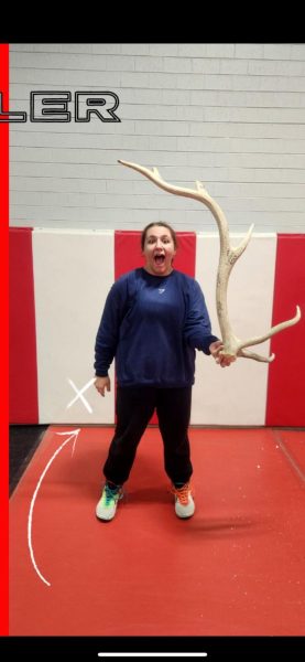 Rowan Statz poses while holding a large antler after winning wrestler of the week. The picture was taken by one of her coaches.
