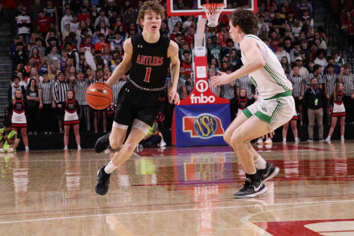 Senior Colin Comstock dribbles past Skutt to the basket. Antlers lost to Skyhawks 61 to 69 in the State Quarter Finals.