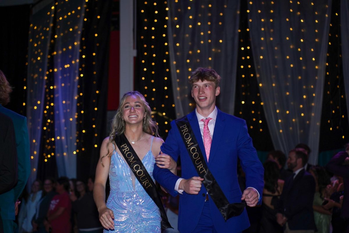 Juniors Addie Hunt and Peyton Turman smile while getting cheered for by the crowd.