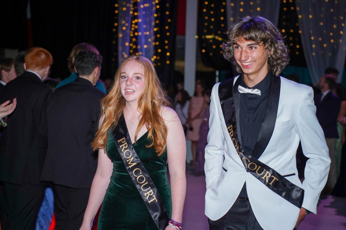 Juniors Claire Polly and Nick Pagliuca smile as they walk through the cheering crowd.