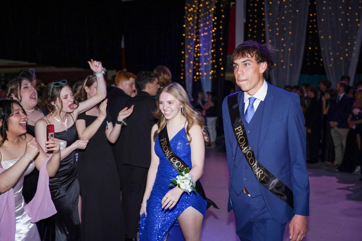 Seniors Darla Crews and Gavin Driffel walking through the cheering crowd as they make their way to the stage.