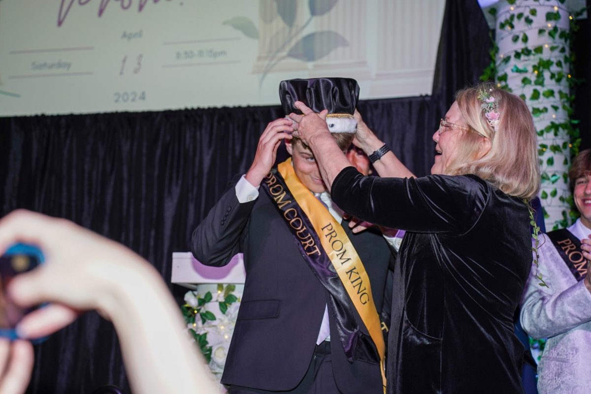 Senior Lance Williams is crowned prom king by EHS administrative assistant Barb Schmidt.