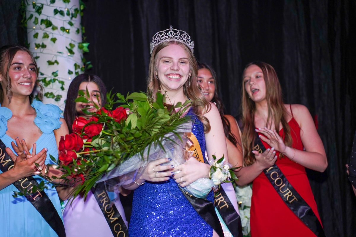 Prom court cheers on Darla Crews as she poses for a photo. 