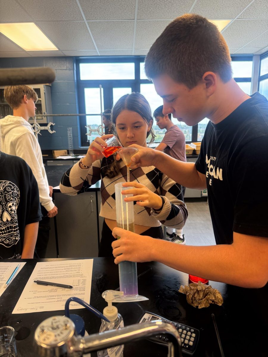 Mr. Stednitz freshmen class pour the liquid through the funnel during their lab.