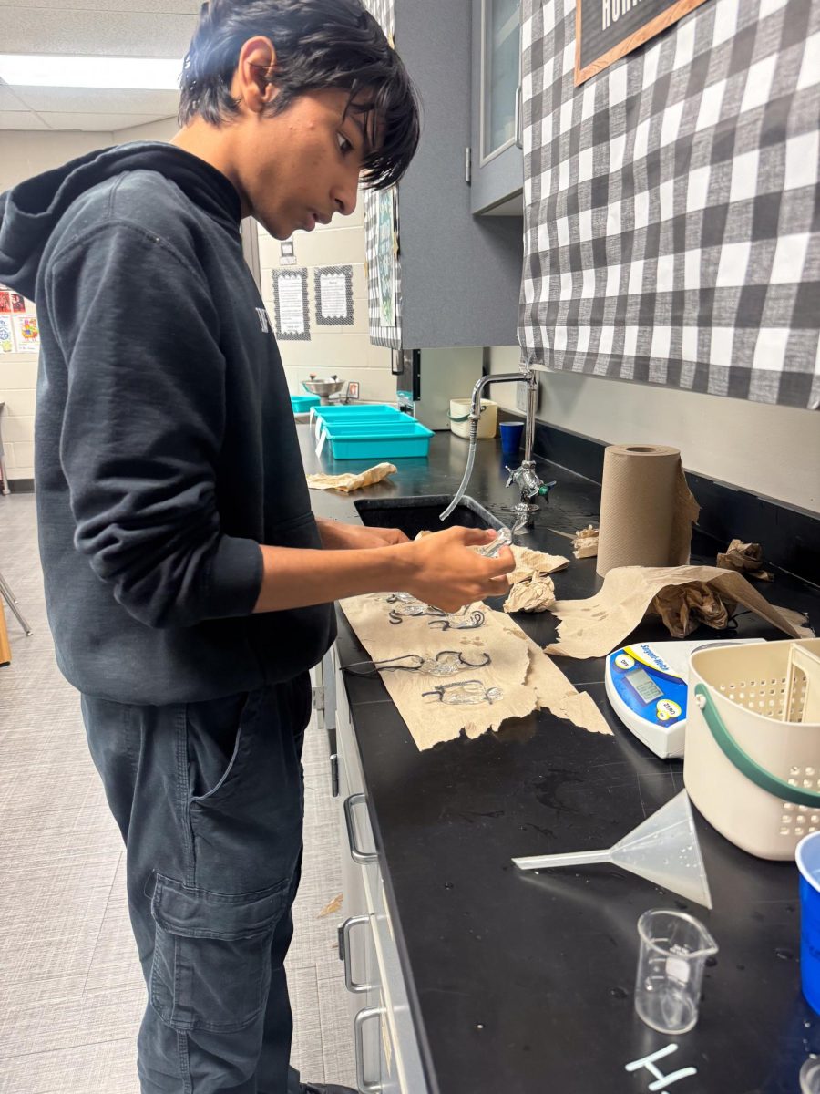 Senior Mateo Graces weighs his dialysis bag during the AP Biology lab.