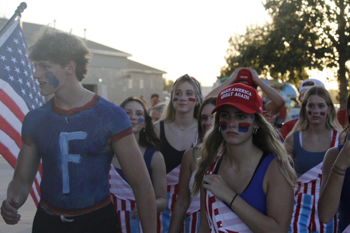 Lauren Fast and Cade Dalton and other members of the paint crew walk onto the stands ready to be laud and support the antlers. The varsity football game was on September 20th with a ending score of 0-28 Waverly. 