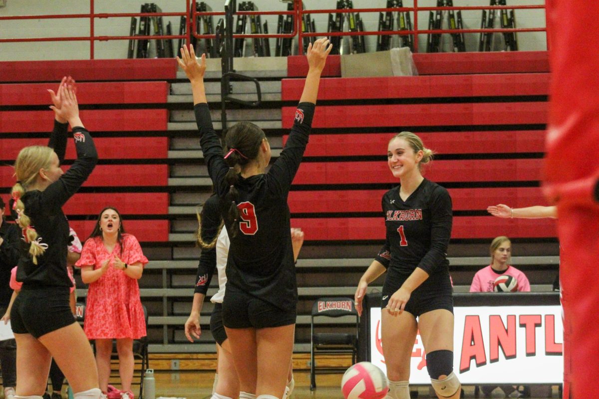 Senior Addie Hunt smiles as her teammates hype her up. This game took place on 10/3, and the Antlers lost to Bellevue East 2-1.