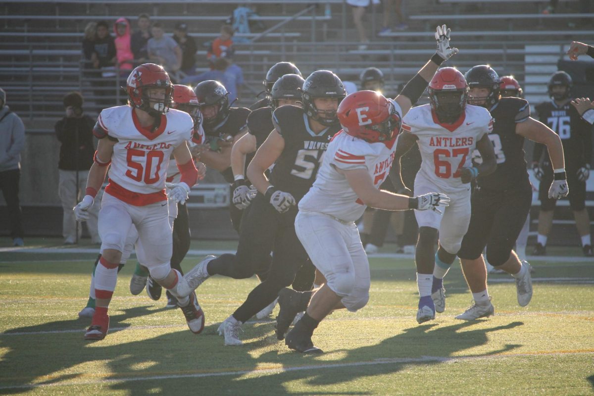 Senior Tim Boomgarden tries to block the throw of the quarterback on Elkhorn North. 