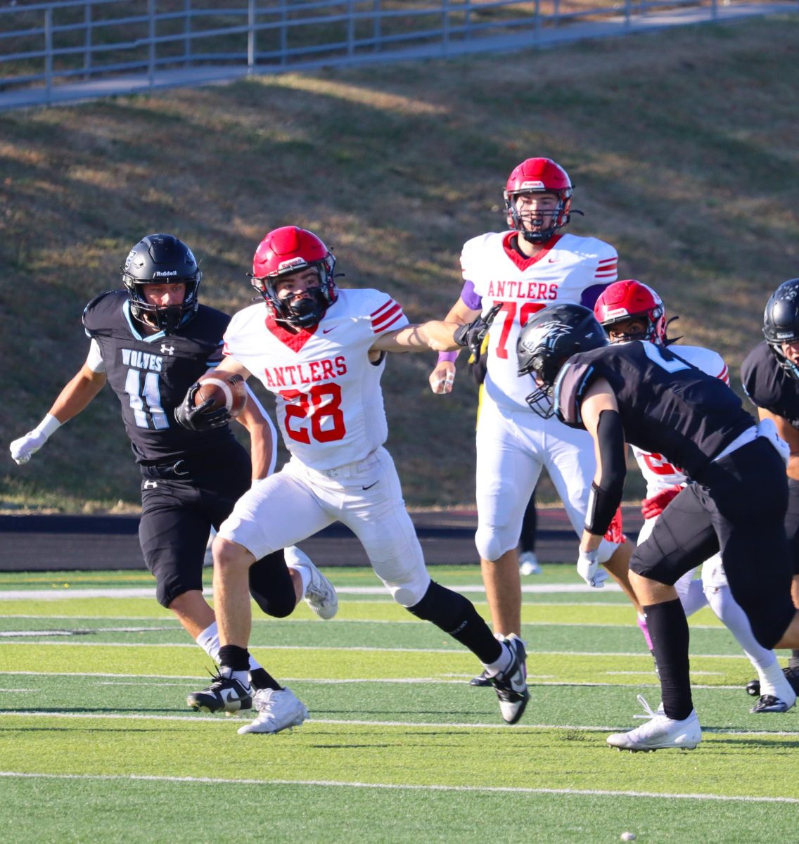 Senior Elliot Beister runs with the ball down the field in attempt to score a touchdown.  The Antlers faced Elkhorn North with a final score of 14-35 in the first round of playoffs.