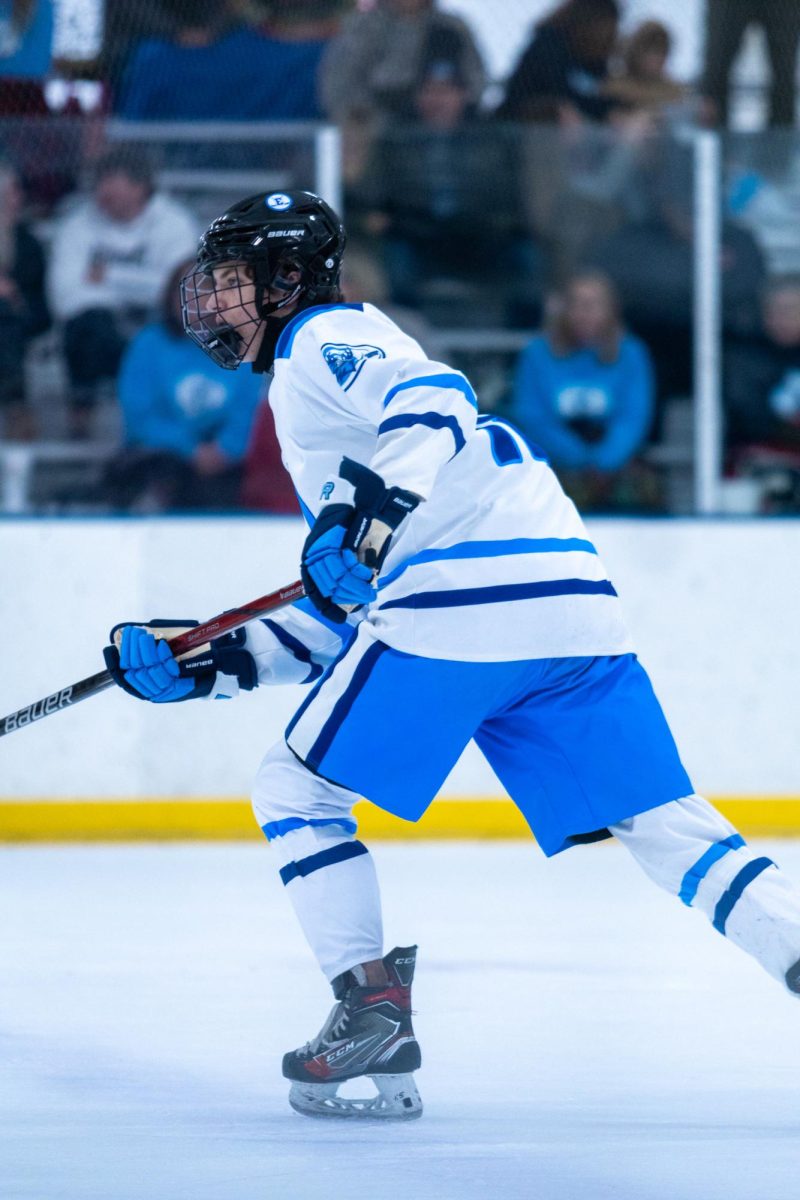 Junior Brody Strohman passes the puck to a teammate. Strohman plays for the Elkhorn Blue club team, which has players from all three Elkhorn high schools.