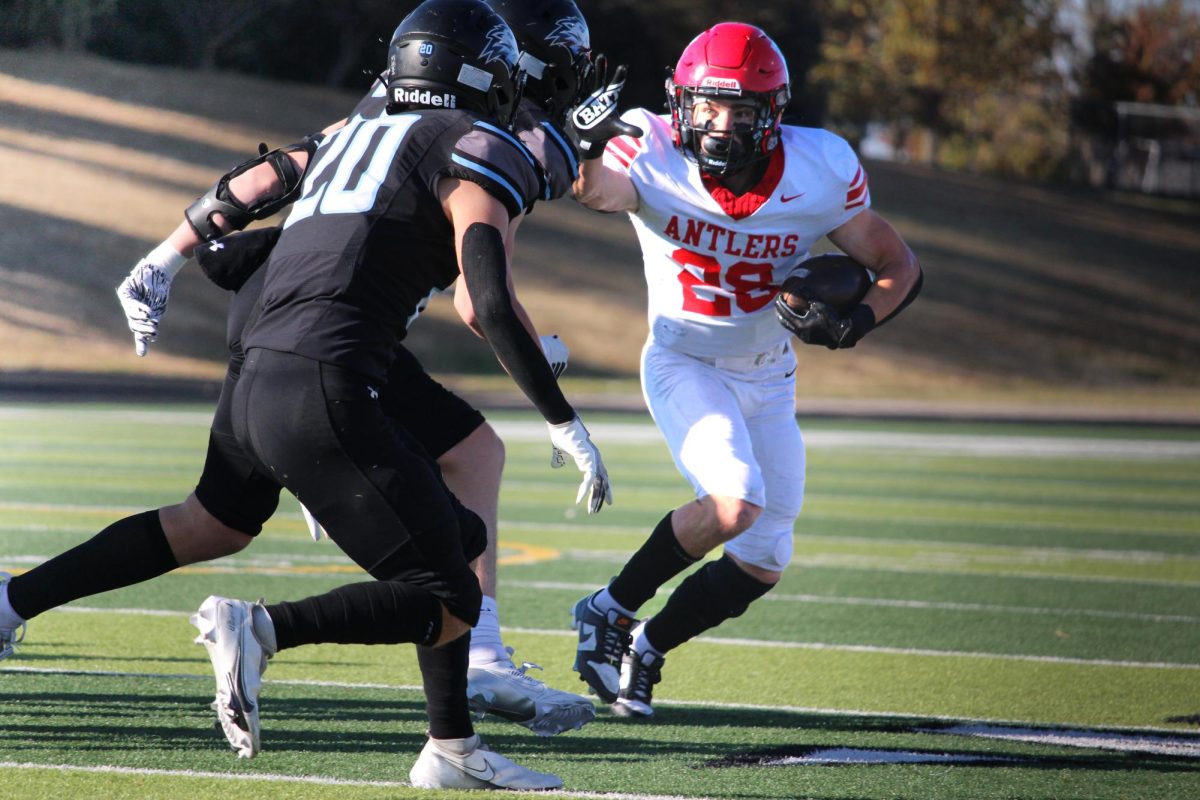 Elliot Beister uses a stiff-arm to run past the defenders. Elkhorn lost to Elkhorn North in the first round of the playoffs, 35-14.