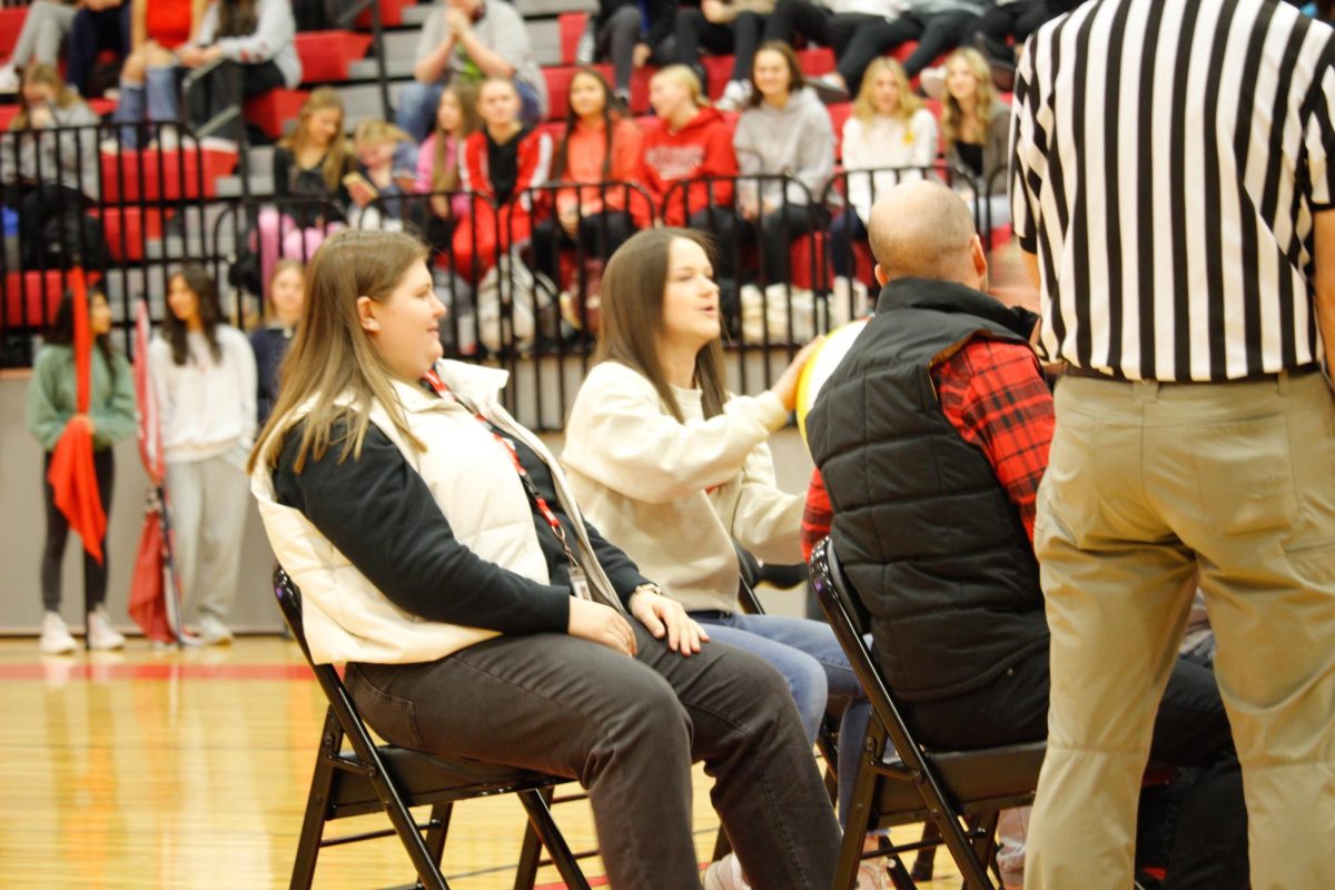 the students vs the teachers in a seated volleyball game Ms. pravecek serving the ball to the students. This happened on January 17th at the pep rally.