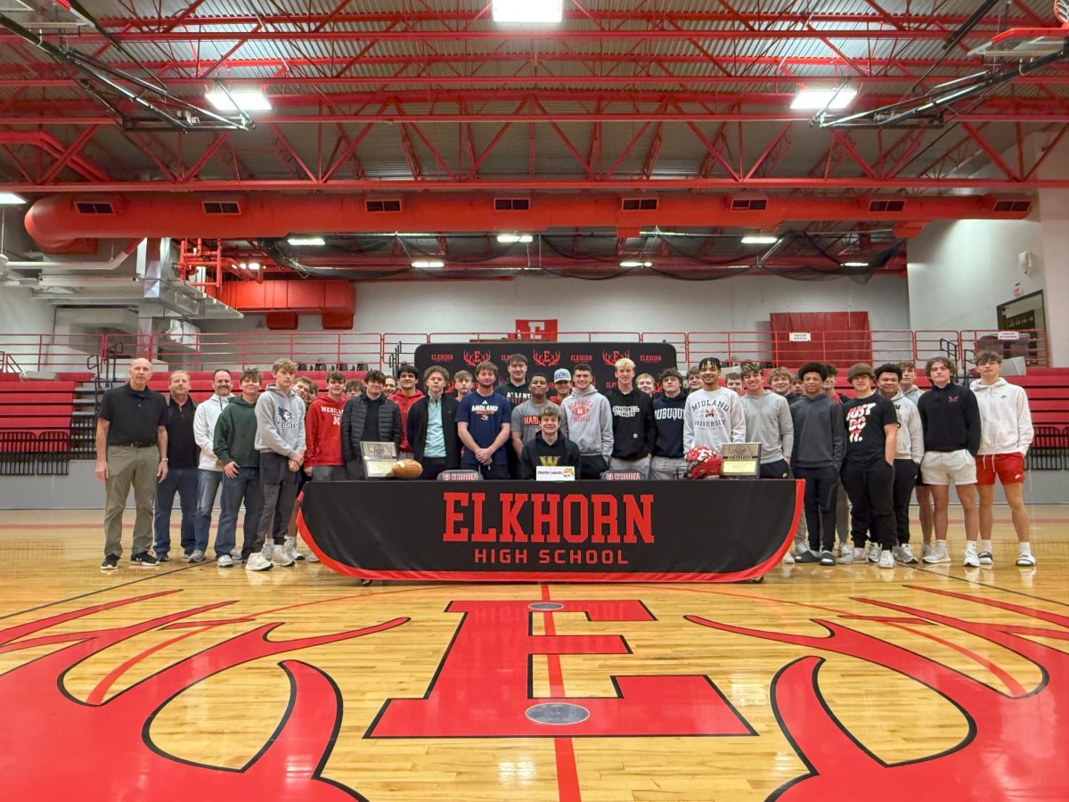 Members of the football team support teammate Charlie Lamski as he signs his letter of intent Feb. 5, 2025. 
Photo courtesy of Elkhorn athletics.