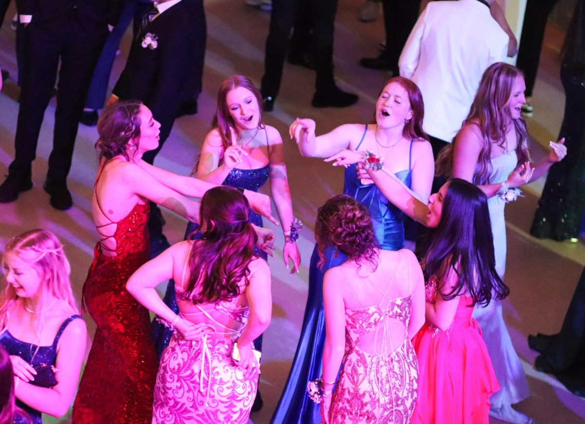 Junior and senior girls dance and sing at prom.