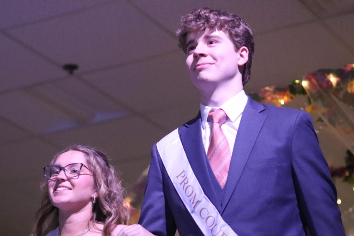 Junior court prince, Stephen Fischer, and Junior Annabelle Bang walking towards the stage for coronation.
