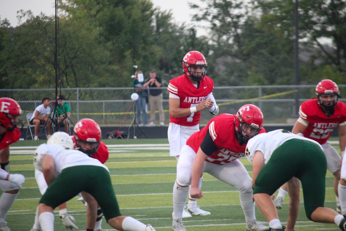 Junior quarterback Baron Clevenger claps to start the play for the Antlers.