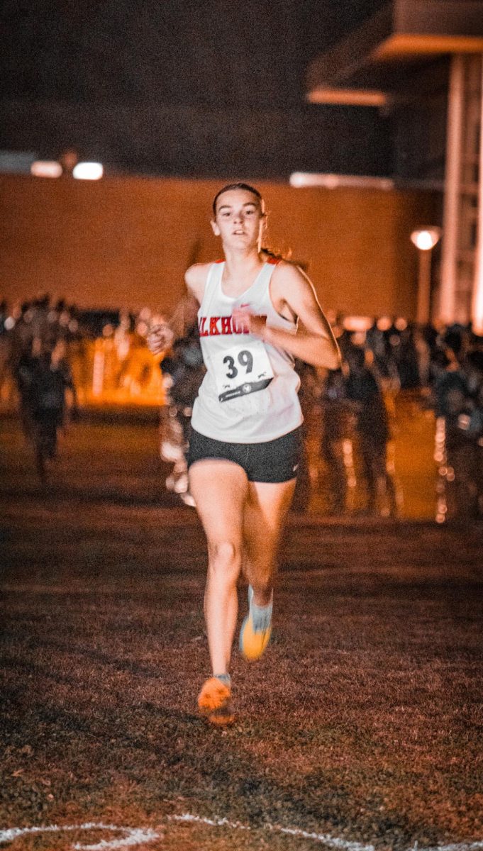 Junior Addison Washburn sprinting to the finish of her 5k race at the Tiger Twilight in Fremont. Washburn would place 10th at the meet with a time of 20.01.