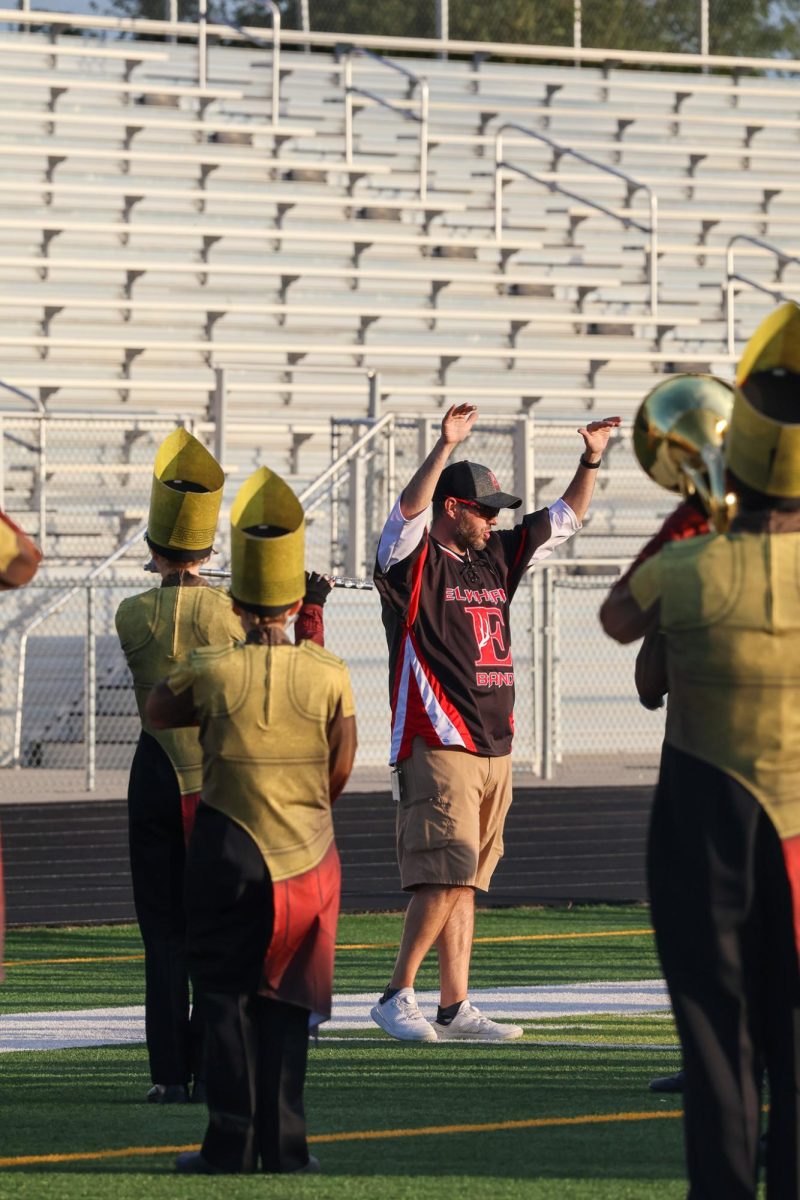 Band director Kyle Dreessen conducts hornline during their warm up. Elkhorn marching band performed on Oct. 11th, 2025.