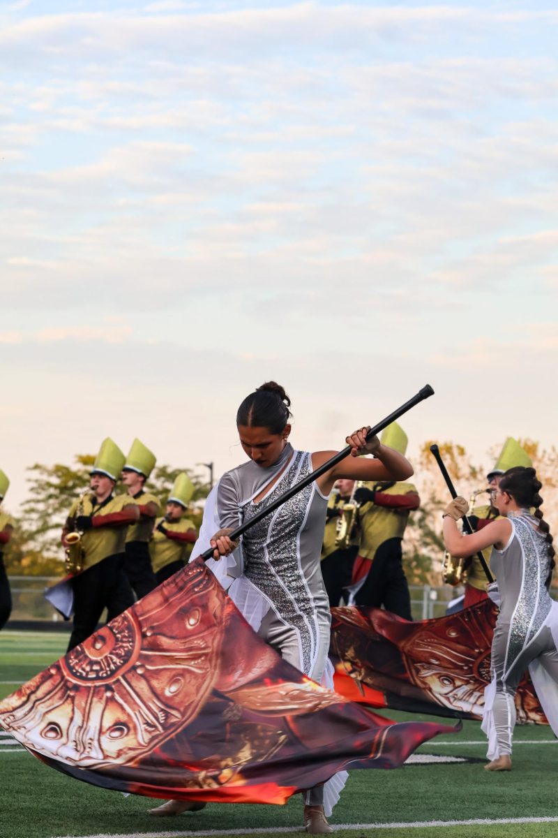 Senior Paige White Bear aggressively performs flag work. Elkhorn marching band performed on Oct. 11th, 2025.