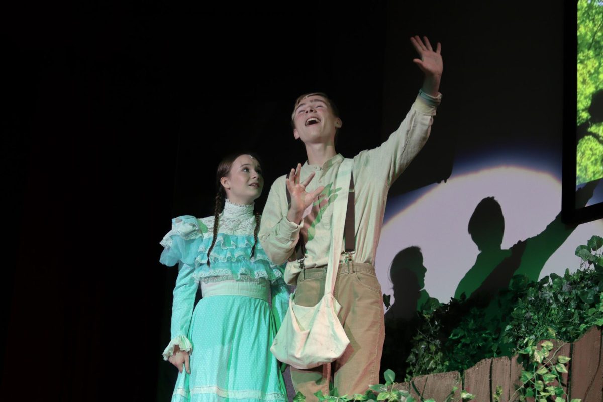 Senior Gage Petrick sings to senior Nola Cowles in the musical "Tuck Everlasting."