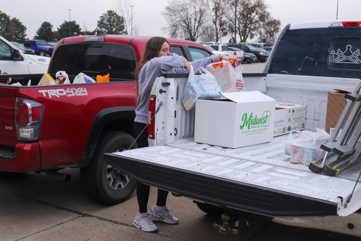 Student _____ unloading food into a truck